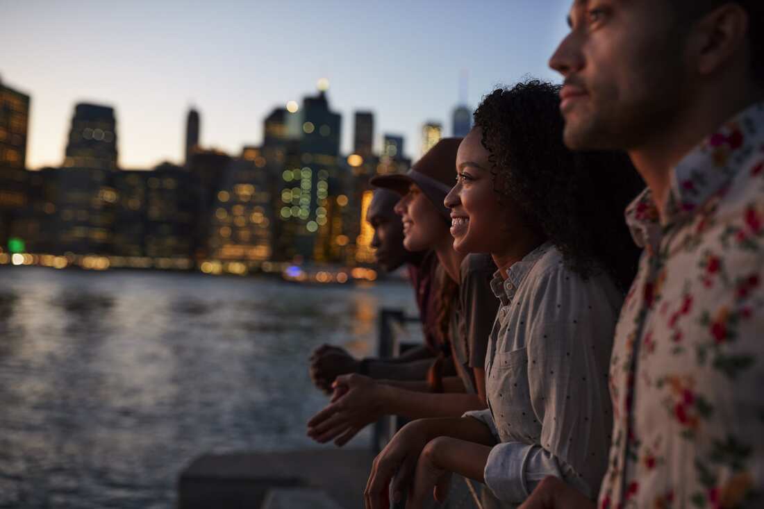 Groups of people smiling by the Hudson river in New York city.